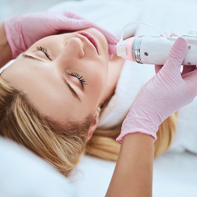 Aesthetic doctor holding a microneedling device to a patients chin