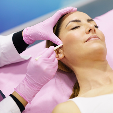 Doctor touching a patients cheek with a white pen like device