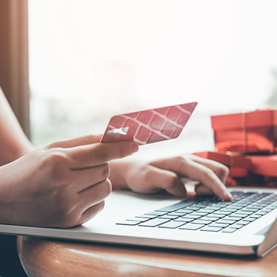 Person entering their credit card information onto a laptop