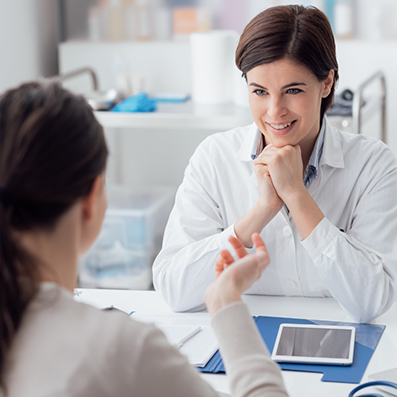 Woman sitting across a desk from her doctor during a consultation